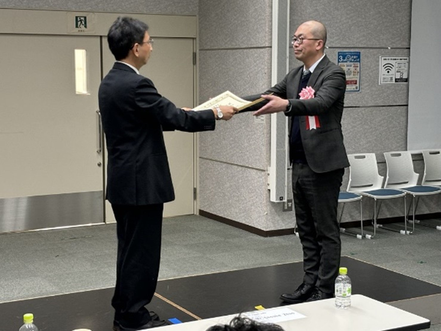 安田恵一郎電気学会長より顕彰状を授与される友野利章社会インフラ部長