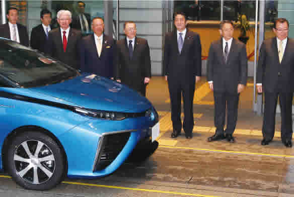 Prime Minister Shinzo Abe (third from right), Hiroya Kawasaki (front left) and others stand beside
the Toyota Mirai