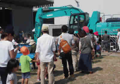 Parents and children operate a real excavator together.