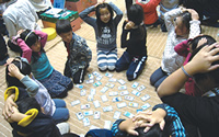 Children playing an eco version of the Japanese card game Karuta