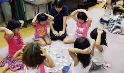 Children playing an eco card game (Shirakawadai Children's Center)