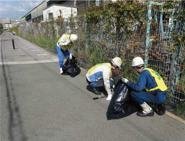 Cleaning up a walkway on the south side of the plant