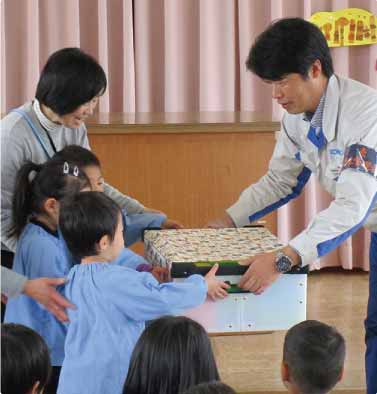 Kindergarten children receiving a large batch of toys (Takasago Works)