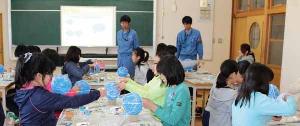 Children creating string globe shades
